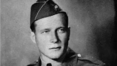 A man wearing a military dress uniform poses for a photo.